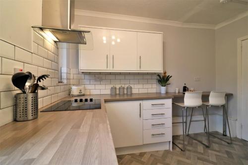 a kitchen with white cabinets and a counter top at Signature - Bruce Terrace Lower in High Blantyre