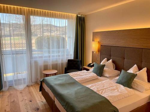 a hotel room with a bed and a large window at Wilfinger Ring Bio Hotel in Hartberg