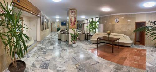 a lobby with a couch and a table and plants at Apart Hotel Central Razgrad in Razgrad