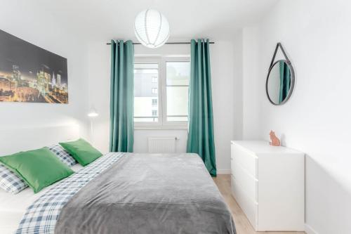 a white bedroom with green curtains and a bed at Enjoy! Ursus in Warsaw
