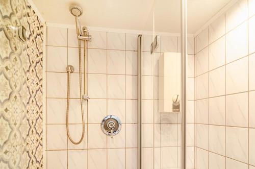 a bathroom with a shower with a shower head at Ferienhaus Segelboot in Krummhörn