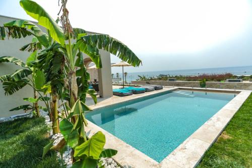 a swimming pool with a view of the ocean at Drymades Inn Resort in Dhërmi