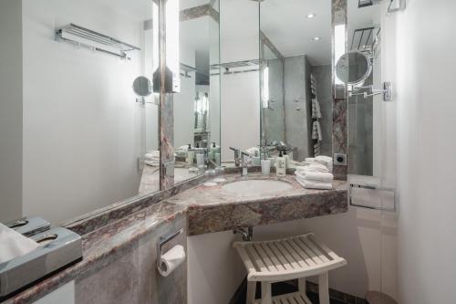 a bathroom with a sink and a mirror and a stool at Villa Ney in Norderney