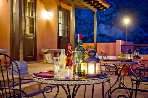 una mesa con botellas de vino y copas en un patio en Tamahuche Hotel Rural, en Vallehermoso