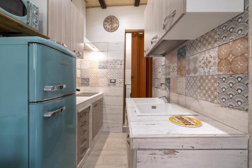 a kitchen with a blue refrigerator and a sink at Dimora Donna Lucrezia in Mola di Bari
