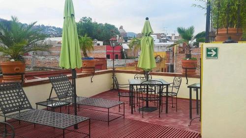 a patio with chairs and tables and umbrellas on a balcony at Hotel Antigua Casa de Piedra in San Miguel de Allende