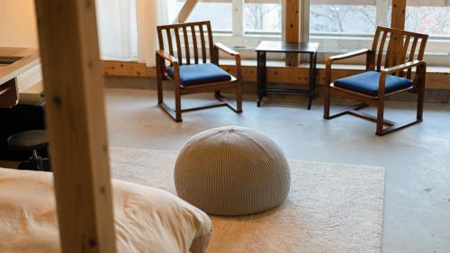 a room with two chairs and a table and a ball on the floor at Nisainoyuyado Asahiya in Beppu