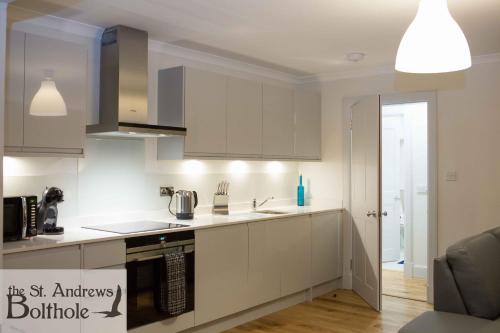 a kitchen with white cabinets and a sink at Luxury in the most convenient location in St Andrews in St. Andrews