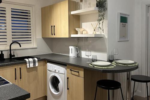a kitchen with a washer and dryer on a counter at Cosy 1BD Getaway Perfect for Couples Stamford in Stamford