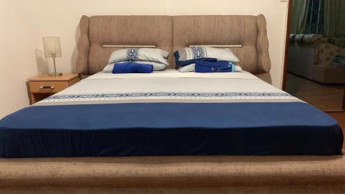 a large bed with blue and white sheets and pillows at White Castle villa in Pereybere