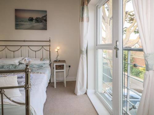 a bedroom with a bed next to a window at Pebble House in Worthing