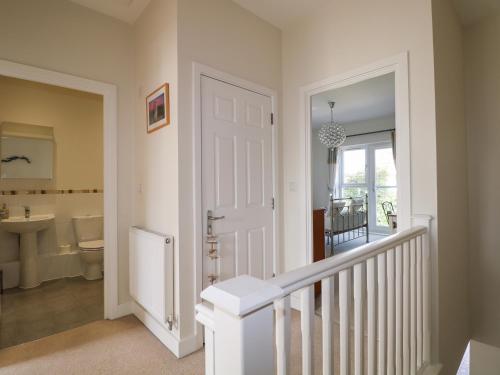 a hallway with a bathroom with a toilet and a sink at Pebble House in Worthing