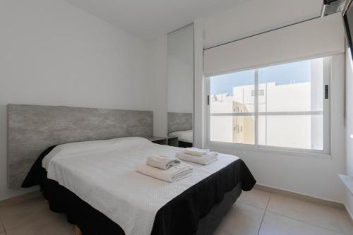 1 dormitorio con 1 cama con toallas en Lumimoso departamento en Buenos Aires 1 dorm en Buenos Aires