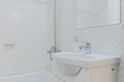Baño blanco con lavabo y espejo en Lumimoso departamento en Buenos Aires 1 dorm en Buenos Aires