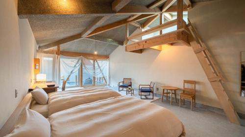 a bedroom with a large bed and a staircase at Nisainoyuyado Asahiya in Beppu