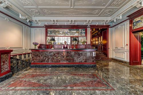 a lobby with a bar with a woman standing behind it at Akyan St.Petersburg in Saint Petersburg