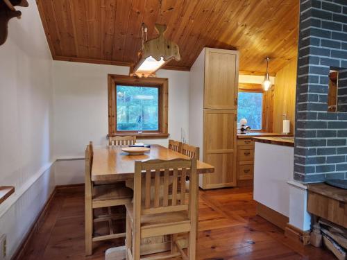 a dining room with a wooden table and chairs at Charmig stuga mitt i naturen! in Upplands-Väsby