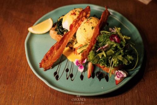 a green plate with food and a salad on a table at Siam Cookies Cottage in Haad Pleayleam