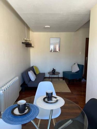 ein Wohnzimmer mit 2 Tischen und einem Sofa in der Unterkunft Elegante Departamento in La Paz