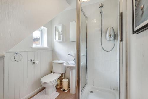 a white bathroom with a toilet and a shower at Pass the Keys Cosy Countryside Cottage in Tonbridge