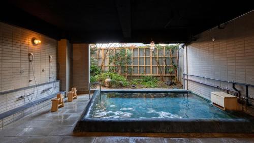 a large pool of water in a large room at Nisainoyuyado Asahiya in Beppu