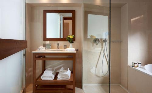 a bathroom with a sink and a shower at St. Nicolas Bay Resort Hotel & Villas in Agios Nikolaos