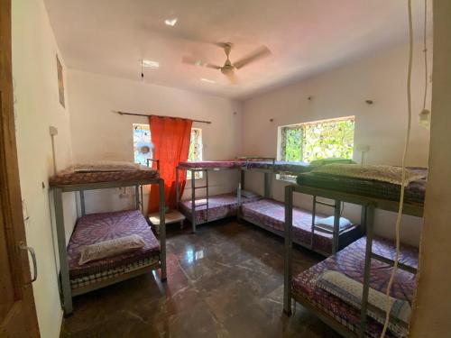 a room with four bunk beds in it at NamahStay Hostel, Cowork & Artist residency Arambol in Arambol