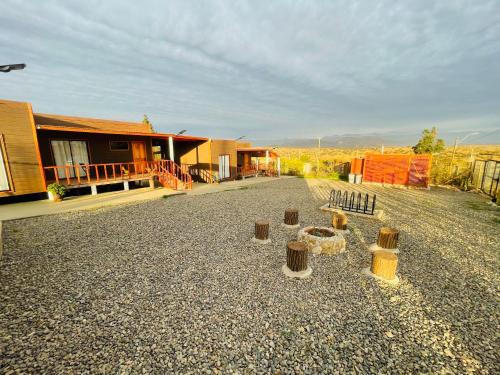 a gravel driveway with wooden posts in front of a house at ELUNEY Combarbala in Combarbalá