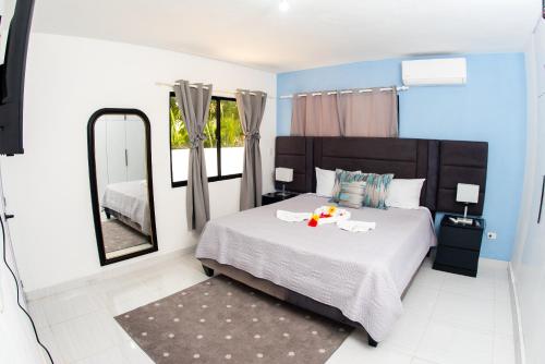 1 dormitorio con cama y espejo grande en Skylight Suites Hotel, en San Felipe de Puerto Plata