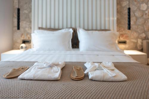 sypialnia z łóżkiem z ręcznikami i butami w obiekcie THERETRA PEFKI Seaside w mieście Pefki