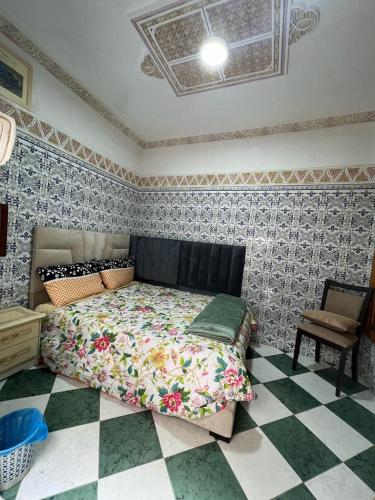 a bedroom with a bed and a checkered floor at Riad Le Palais in Rabat