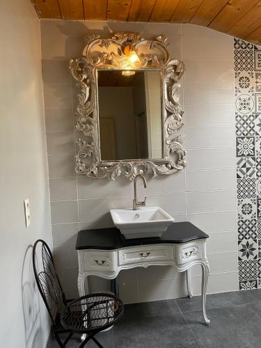 a bathroom with a sink and a mirror on the wall at Maison d'Emmannaelle in Auros