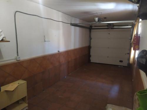 a garage with a white door and a tiled floor at Habitacion Privada Familiar Toledo in Toledo