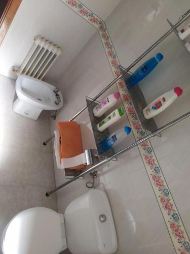 a bathroom with a white toilet and a sink at Habitacion Privada Familiar Toledo in Toledo