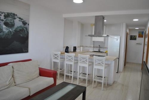 a living room with a couch and a kitchen at Apartamentos la Caracola in Adra