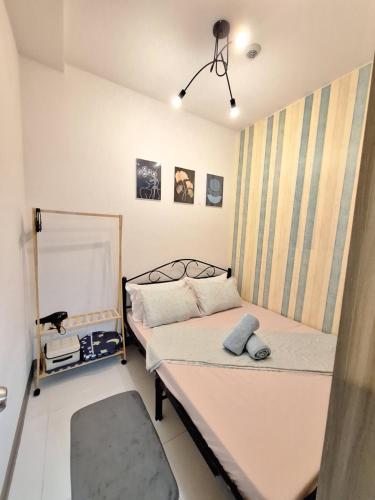 a small bedroom with two beds and a mirror at Coast Residence Pasay in Manila