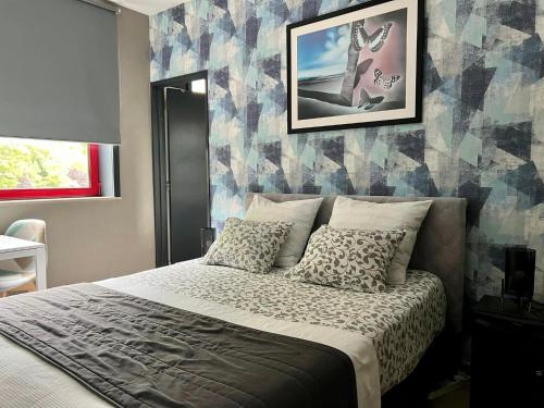 Schlafzimmer mit einem Bett mit gemusterter Wand in der Unterkunft Haras des Chartreux in Estaimbourg
