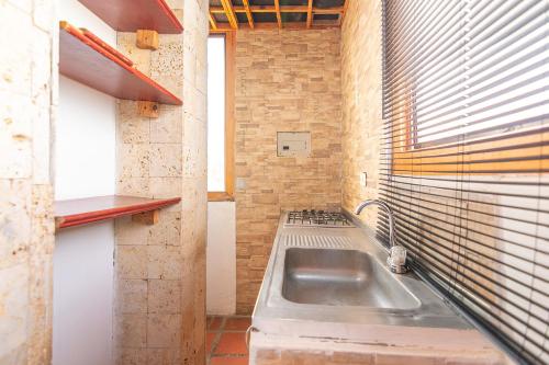 a kitchen with a sink and a brick wall at Ayenda Brisas del Caribe in Santa Marta