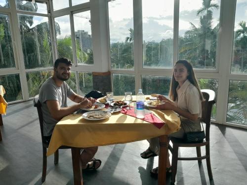 Een man en een vrouw die aan een tafel eten. bij Crown & Crown Kandy in Kandy