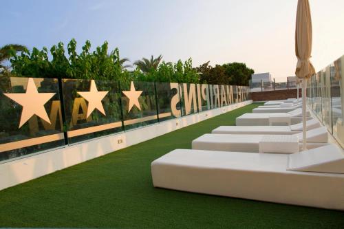 a row of white chairs with stars on the side of a building at ALEGRIA Maripins in Malgrat de Mar