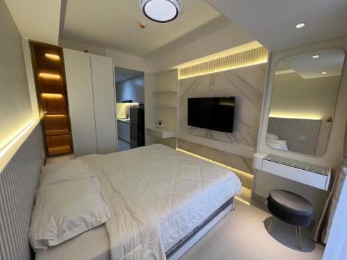een slaapkamer met een bed en een flatscreen-tv bij Pollux Habibie Studio Batam 53F (Seaview) in Batam Center