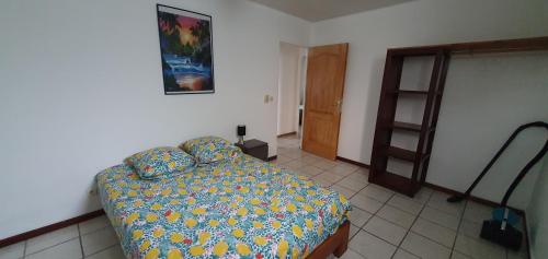 1 dormitorio con 1 cama en una habitación con puerta en Ô CAP en Saint-Benoît
