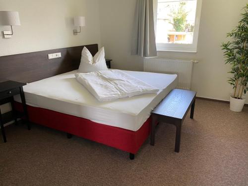 ein großes Bett in einem Zimmer mit einem Schreibtisch und einem 6 x 6 cm großen Bett in der Unterkunft Appartements am Schaalsee in Zarrentin