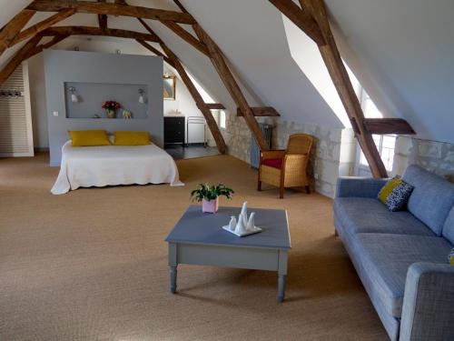 uma sala de estar com um sofá e uma cama em Chambres d'Hôtes Rue du Poids em Bourgueil