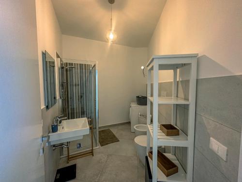 a bathroom with a sink and a toilet and a mirror at Dimora Mediterranea in Augusta