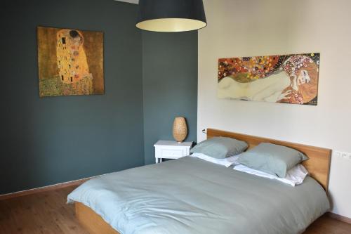 a bedroom with a bed and two paintings on the wall at Casa Frida in Ostend
