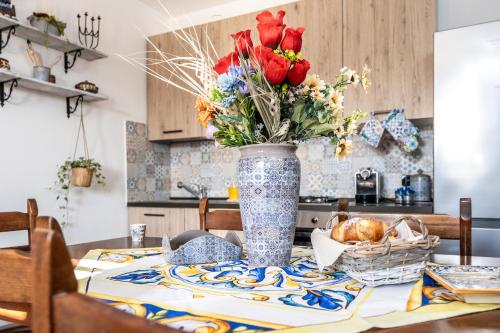 Un posto al sole - Caltanissetta في كالتانيسيتا: إناء من الزهور على طاولة في مطبخ