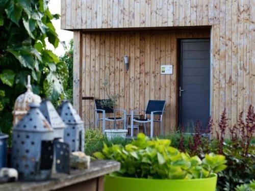 a garden with a house with chairs and a plant at Le Chalet Champenois in Bethon