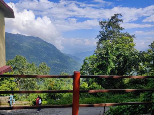 una valla con vistas a un valle de montaña en Kolakham Rai Paul Residency Homestay, en Lava