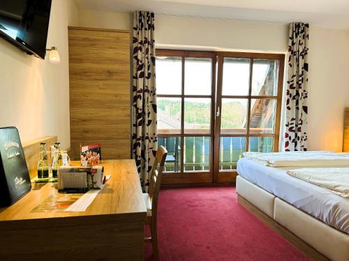 Habitación de hotel con cama, escritorio y ventana en Gasthaus und Landhotel Wiedmann, en Eresing